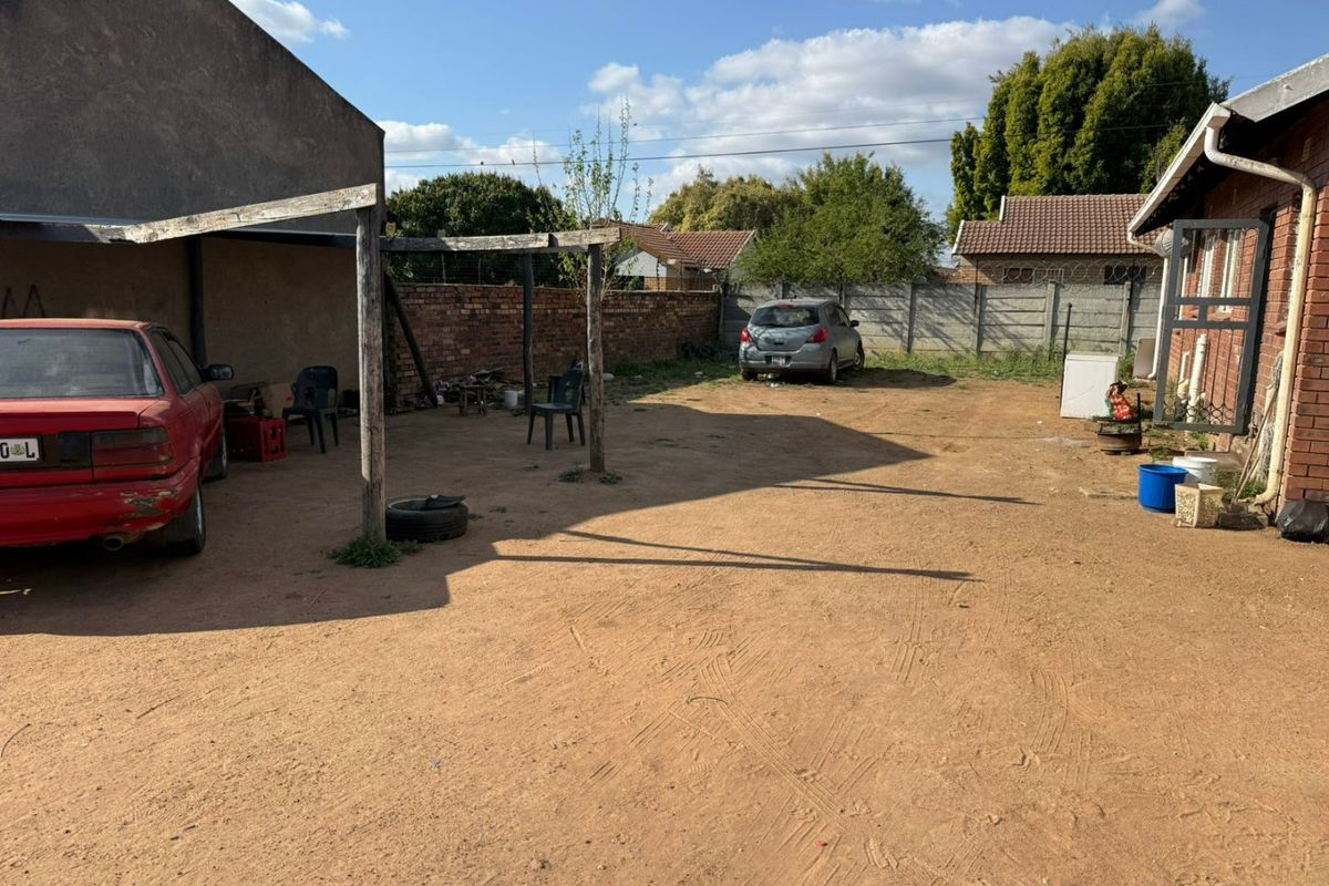 Spacious rear yard featuring a brick boundary wall and a timber pergola structure, offering significant potential for landscaping and outdoor improvement.