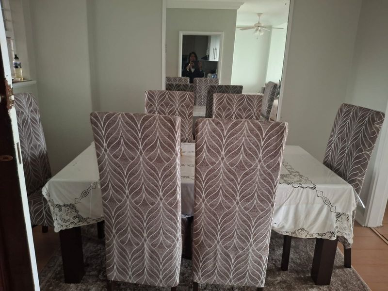 A dining room featuring laminate flooring and a large wall mirror, providing a functional space for meals.