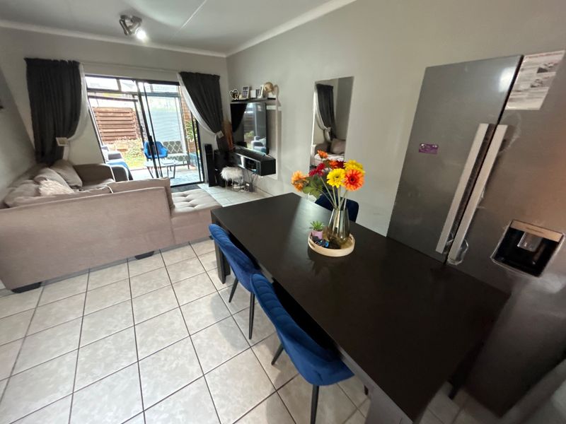 Open-plan living and dining area featuring tiled flooring and a sliding glass door providing access to the outdoor patio space.