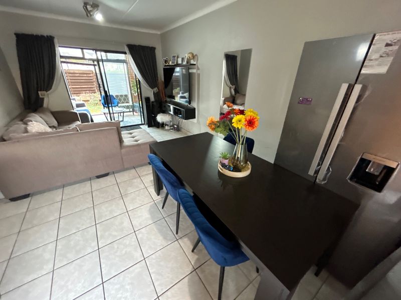 Open plan living and dining area featuring tiled flooring and a sliding glass door providing access to the outdoor patio space.