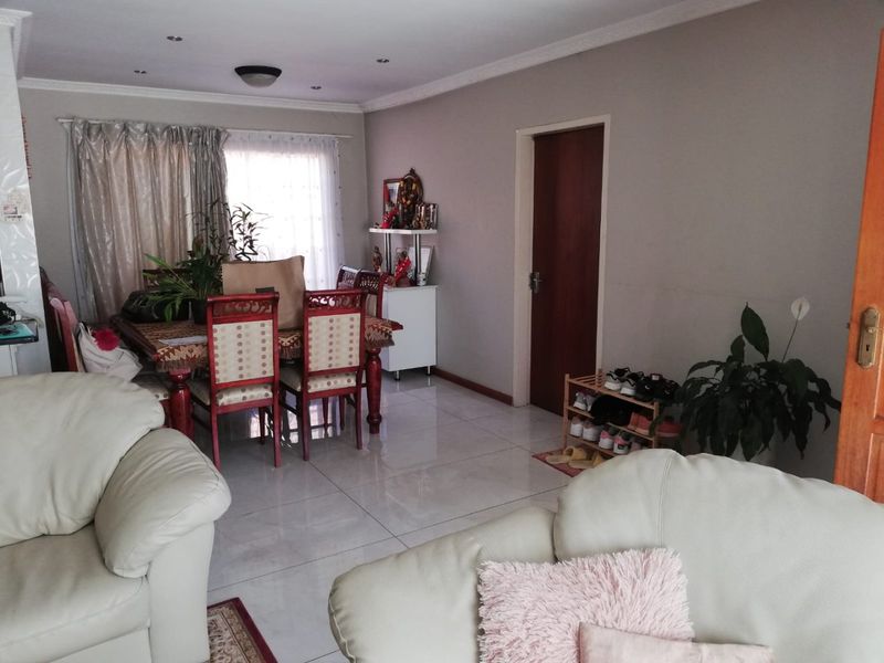 Open plan living and dining area featuring polished tiled flooring, recessed ceiling lighting, and coved cornicing throughout the space.