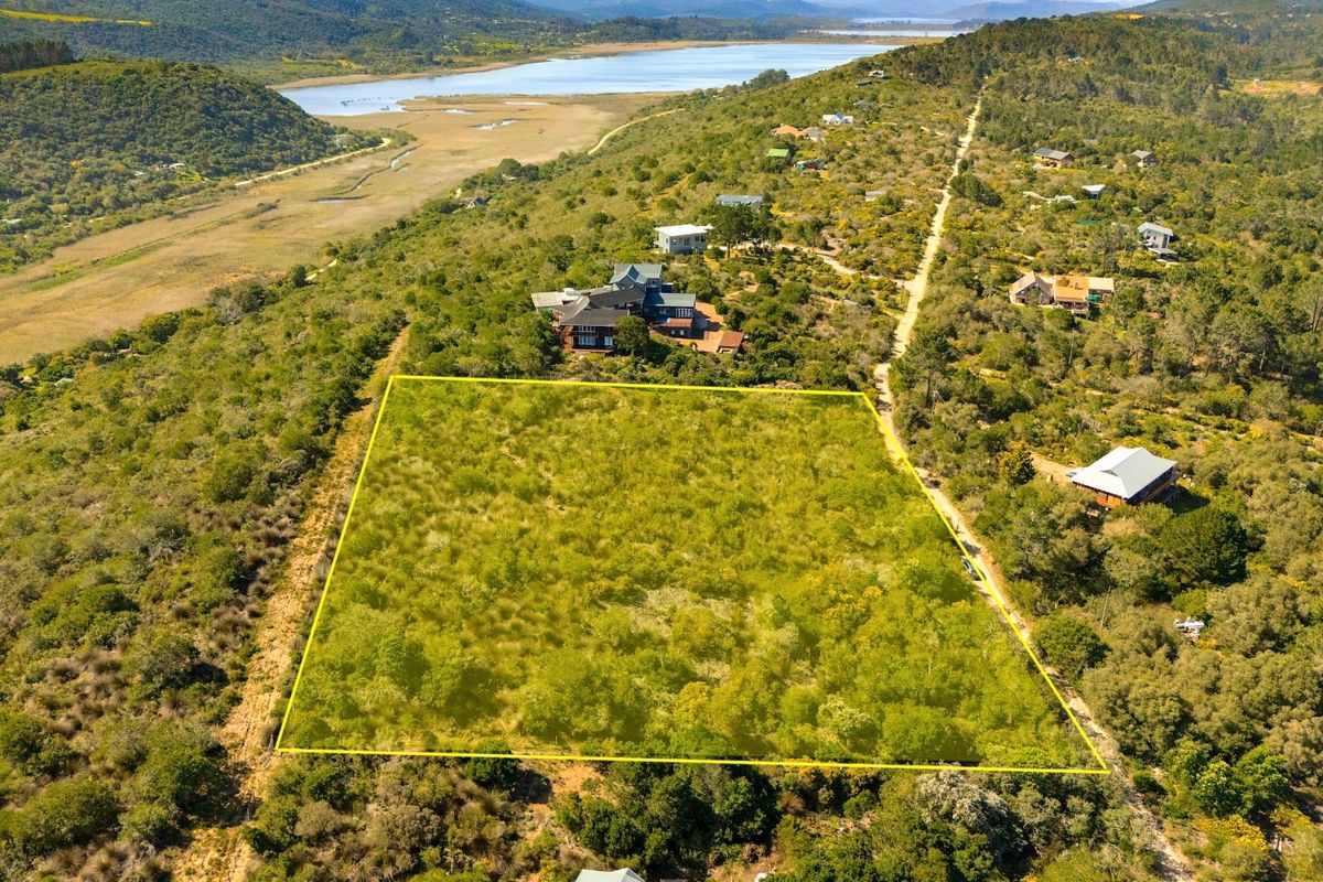 Aerial view of a vacant residential plot featuring natural vegetation and surrounding landscape views.