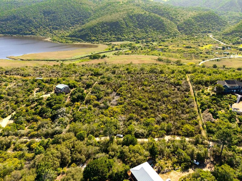 Aerial view of a large, undeveloped residential plot featuring natural vegetation and surrounding landscape views.