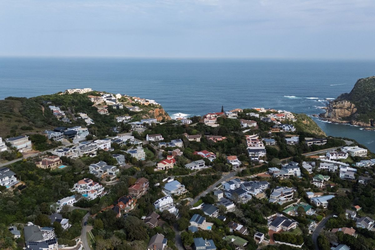 An aerial view of a coastal residential estate overlooking the ocean and surrounding landscape.
