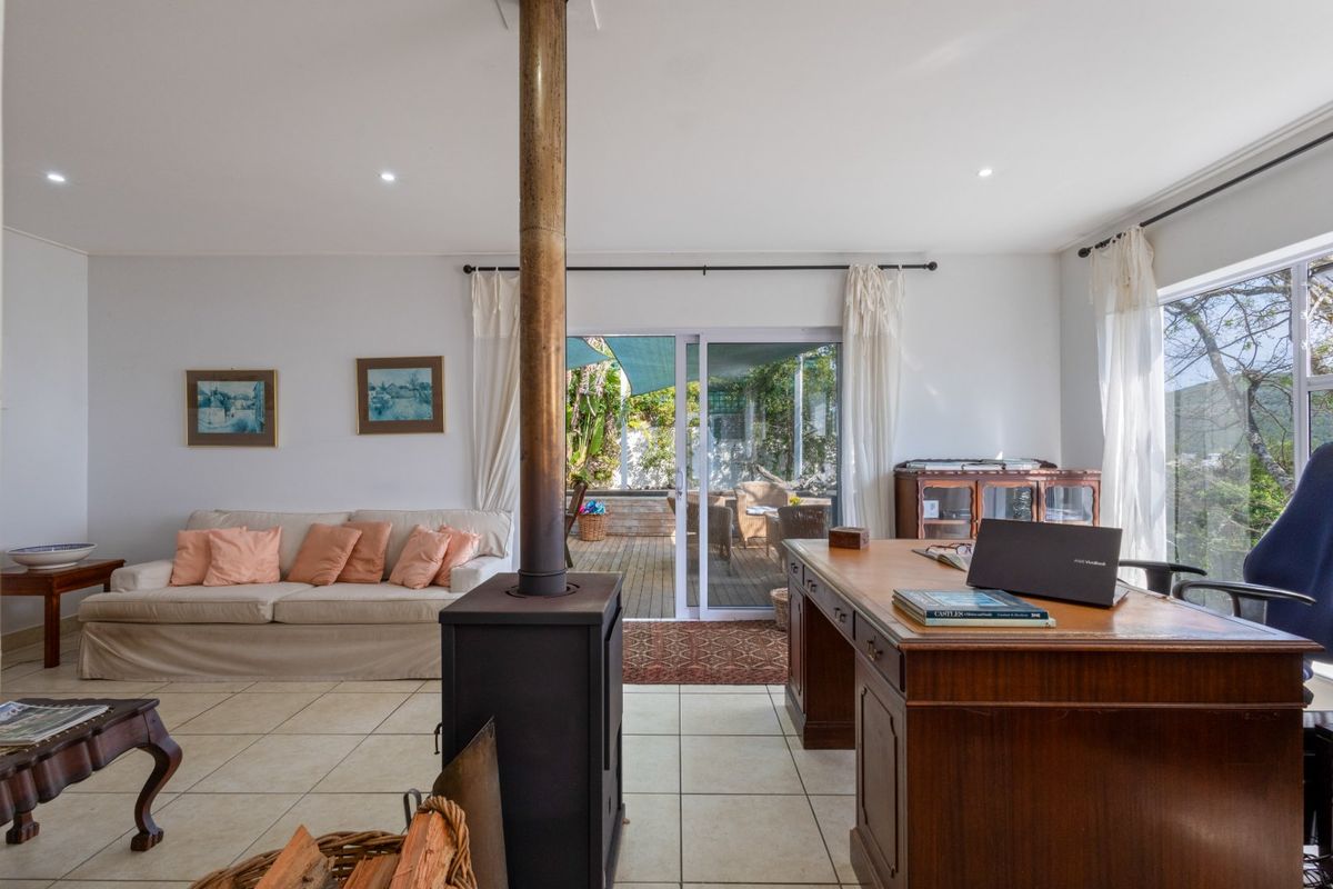 Spacious living room featuring a central freestanding fireplace, tiled flooring, and large sliding glass doors providing direct access to the outdoor patio area.