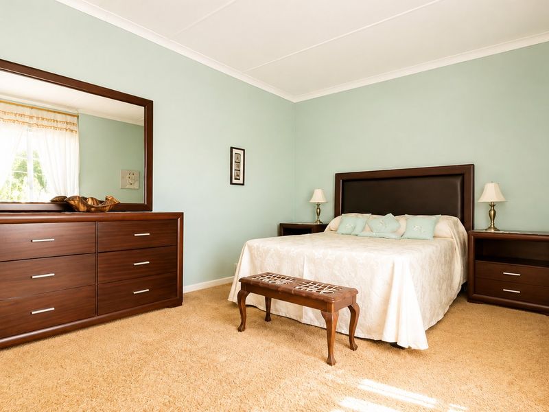 A well-maintained bedroom featuring neutral carpet flooring and coved ceiling cornices, providing a comfortable and functional living space.