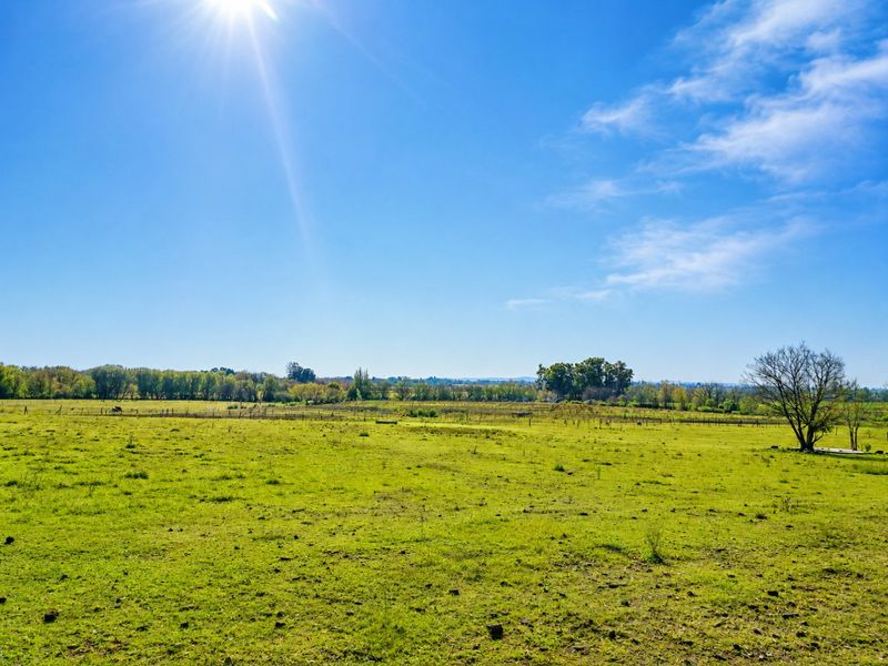 Expansive open pasture land featuring natural landscape views and perimeter wire fencing, ideal for agricultural or equestrian use.