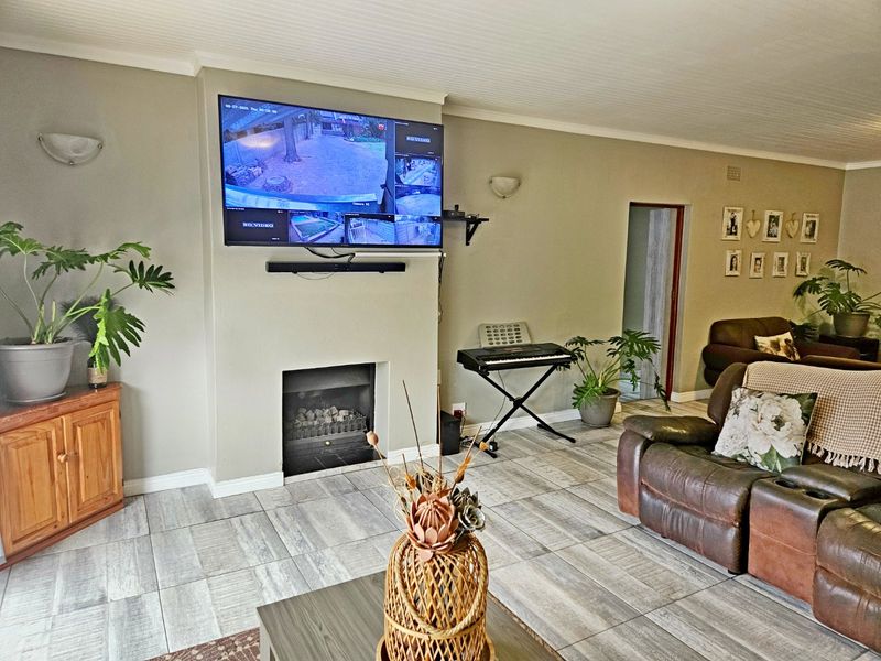 A comfortable living room featuring a built-in fireplace, neutral wall tones, and modern wood-look tiled flooring.