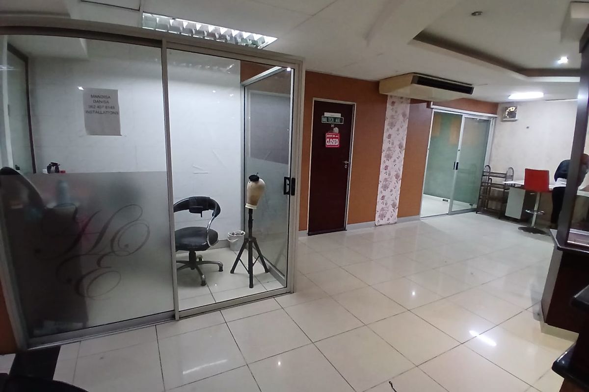Commercial office space featuring glass partitioned rooms, tiled flooring, and recessed lighting, suitable for a professional service or salon environment.