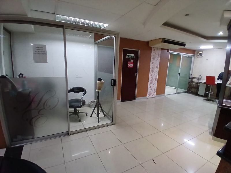 Commercial office space featuring glass partitioned rooms, tiled flooring, and recessed lighting, suitable for a professional service or salon environment.