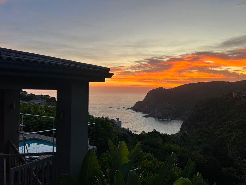 Stunning sunset view over the ocean and coastline, featuring a private swimming pool and modern balcony balustrading.