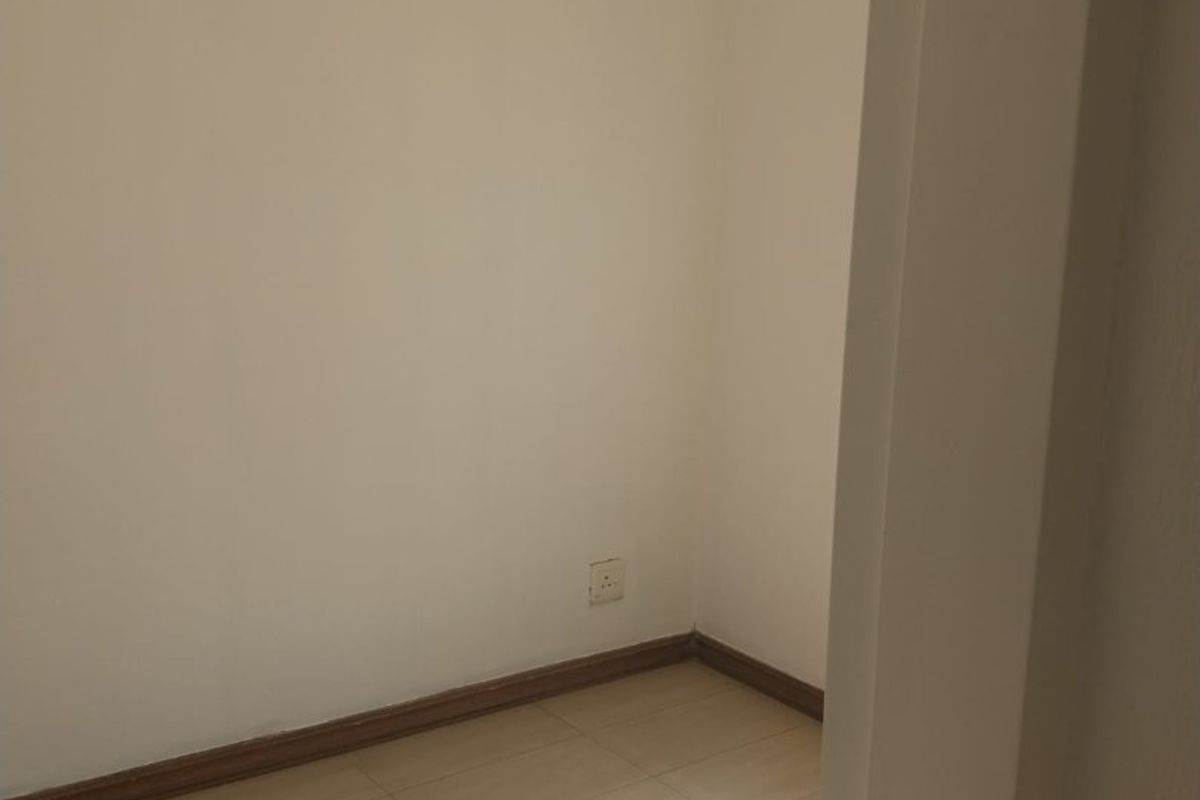 A vacant bedroom featuring neutral tiled flooring and clean white walls, offering a blank canvas for personalization.