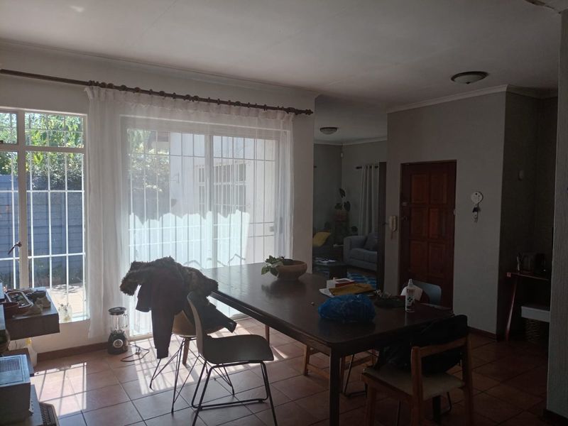 Dining area featuring tiled flooring, large sliding glass doors with security bars, and direct access to the exterior.