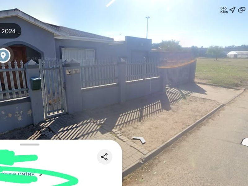 Street view of the property showing the front perimeter wall, pedestrian gate, and tiled roof structure.