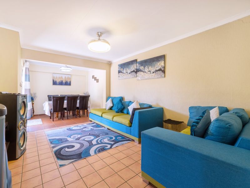 Open-plan living and dining area featuring tiled flooring and coved ceilings, providing a functional space for family gatherings.