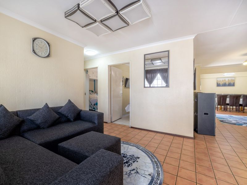 Open plan living and dining area featuring tiled flooring and neutral wall finishes, providing a functional layout with access to adjacent rooms.