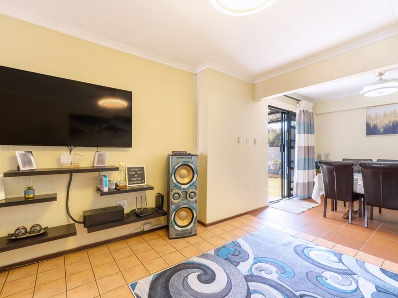Open plan living and dining area featuring tiled flooring, neutral walls, and a sliding glass door providing access to the outdoor space.