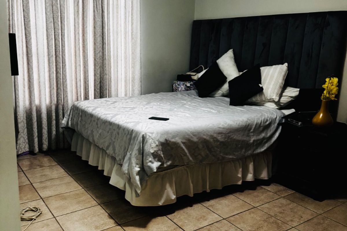 A bedroom featuring tiled flooring and neutral wall finishes, providing a functional space with a classic layout.