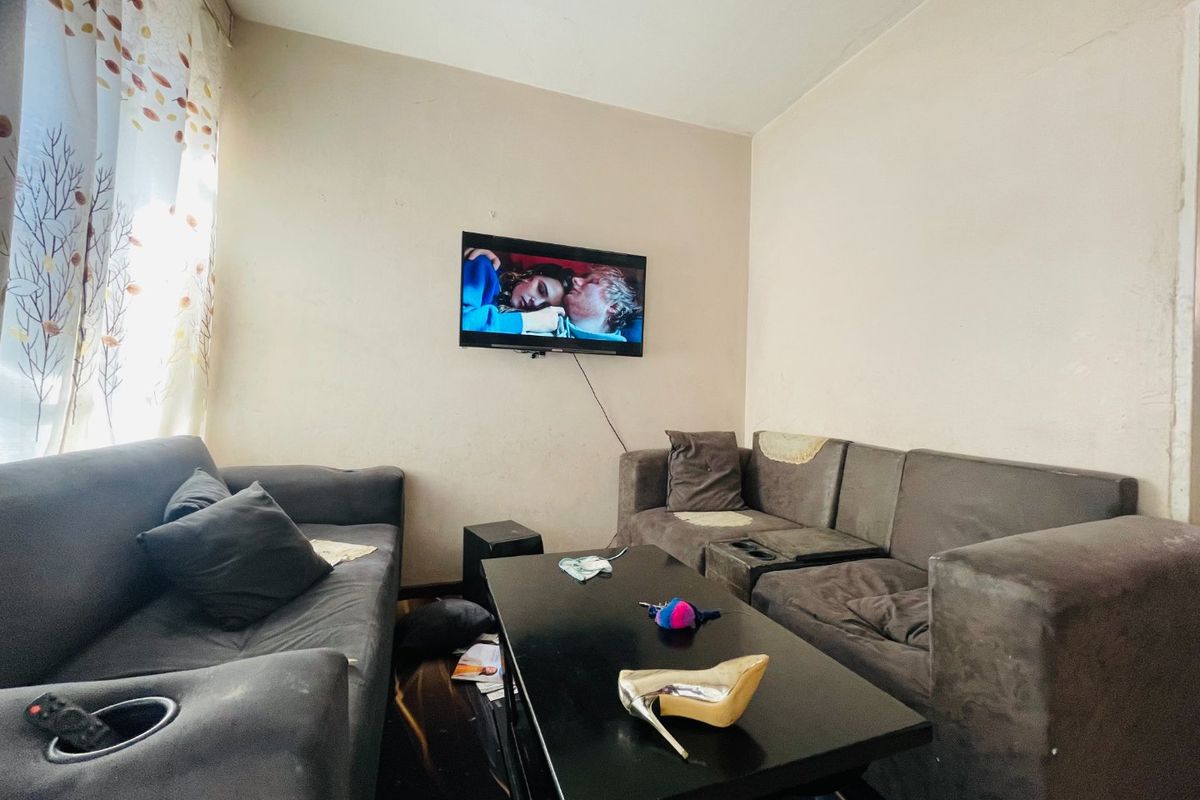 A compact living room area featuring neutral wall finishes, suitable for renovation or restyling to enhance the space's overall appeal.