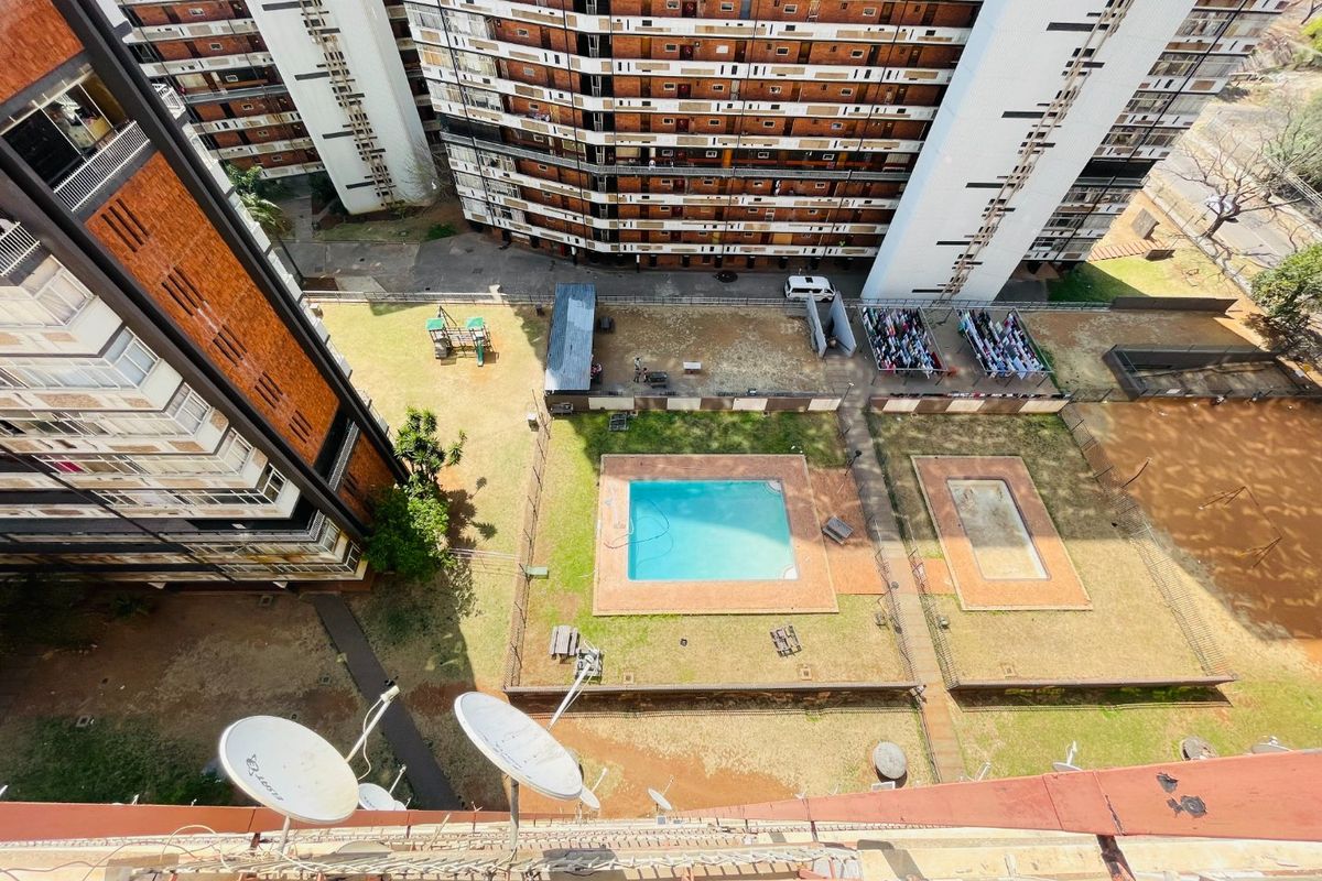 Aerial view of the apartment complex grounds featuring a swimming pool, wading pool, and communal outdoor space.