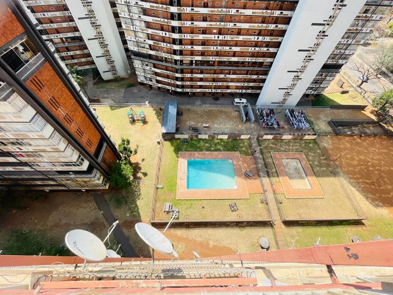 Aerial view of the apartment complex grounds featuring a swimming pool, wading pool, and communal outdoor space.
