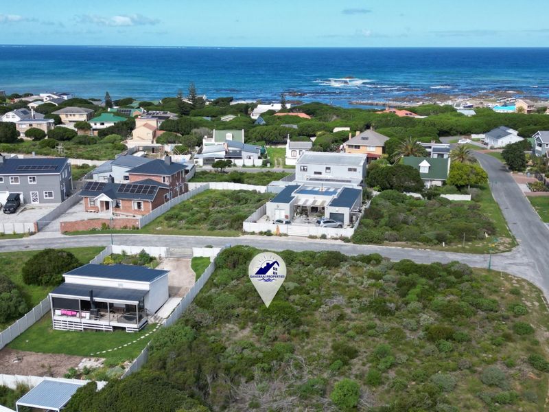 Aerial view of a vacant residential plot situated in a coastal neighborhood, offering proximity to the ocean and established residential infrastructure.