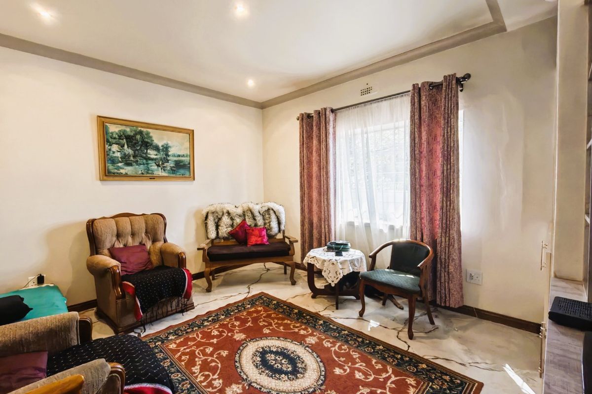 A living room featuring marble-look tiled flooring, recessed downlighting, and a coved ceiling, providing a neutral base for interior updates.
