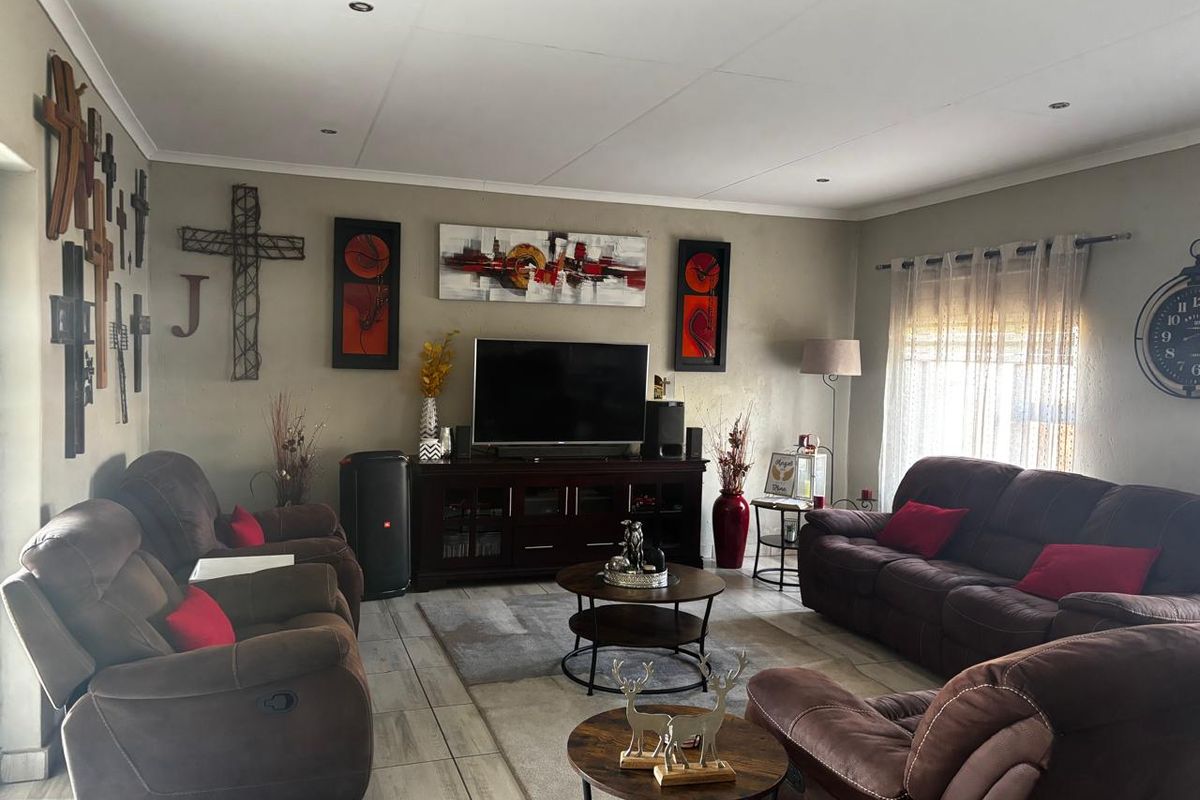 A comfortable living room featuring tiled flooring and recessed ceiling lighting, providing a functional and well-lit space for relaxation.