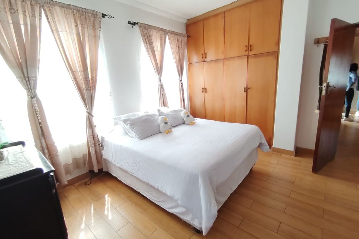 A bedroom featuring laminate flooring, recessed lighting, and extensive built-in wooden cabinetry for storage.