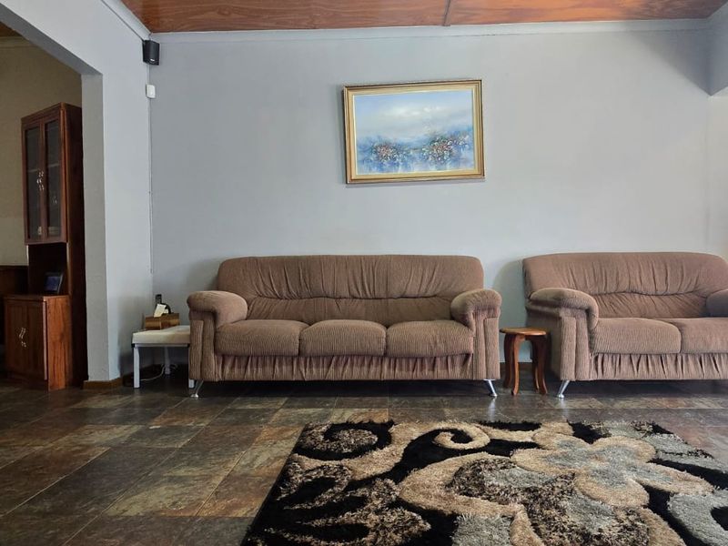 A spacious living room featuring durable tiled flooring and a warm timber ceiling, offering a comfortable and functional layout for family relaxation.