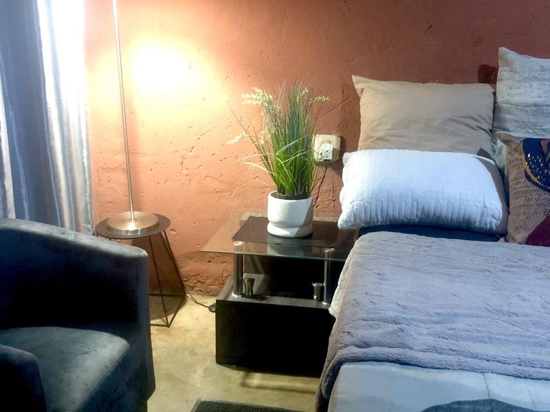 A bedroom interior featuring a textured wall finish and standard electrical infrastructure.