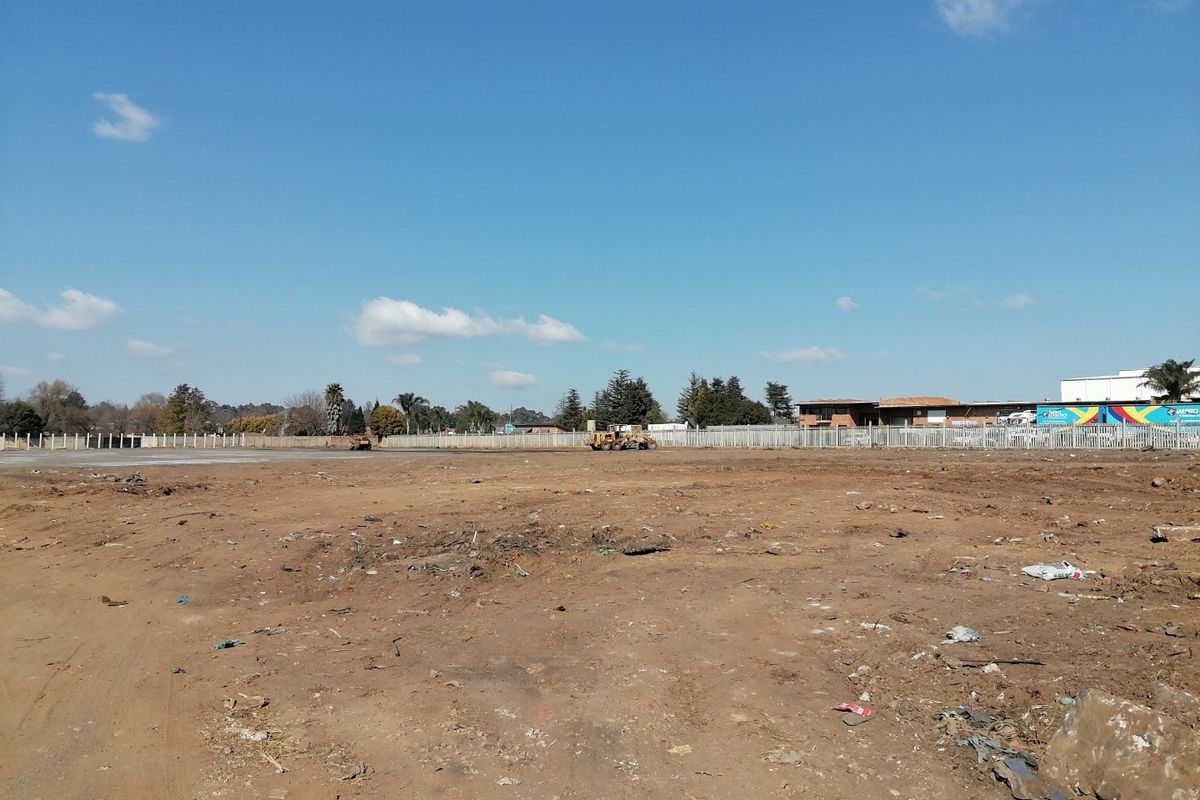 A vacant residential plot of land featuring perimeter fencing and cleared ground, ready for development.