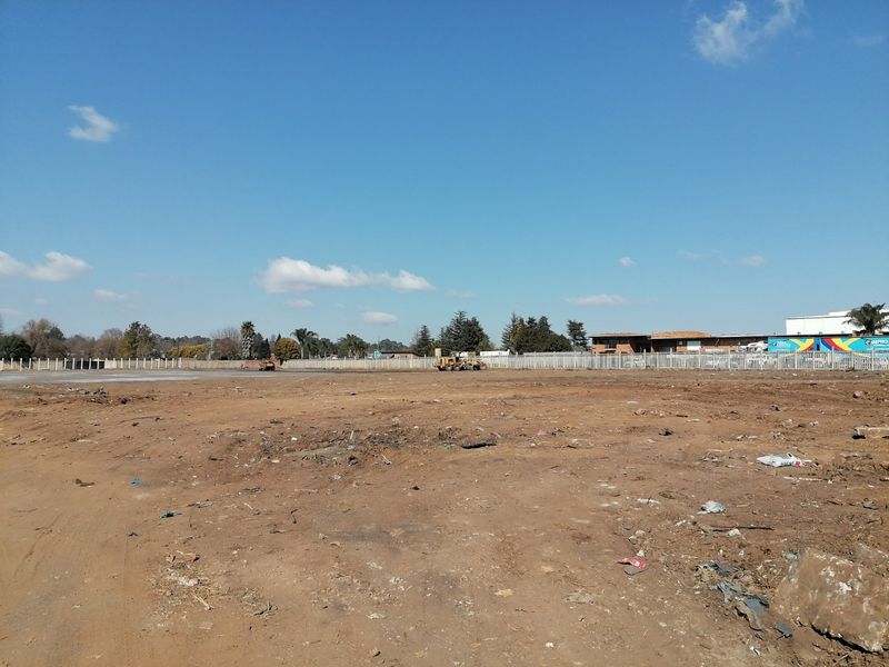 A vacant residential plot of land featuring perimeter fencing and cleared ground, ready for development.