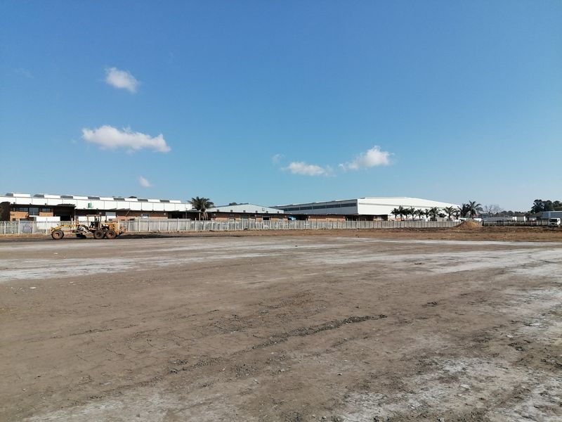 A wide-angle view of a cleared, vacant residential plot featuring perimeter fencing and level ground, ready for development.