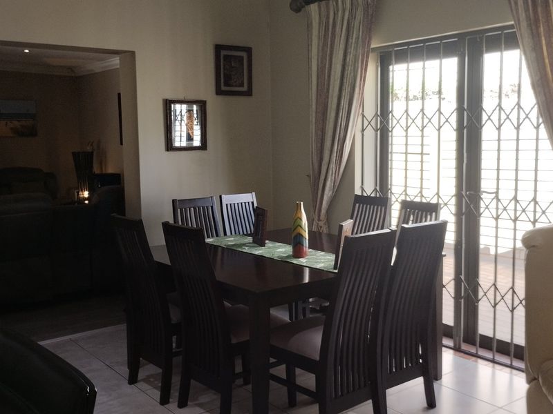 Dining area featuring tiled flooring and a sliding glass door with a security gate, providing access to the outdoor space.