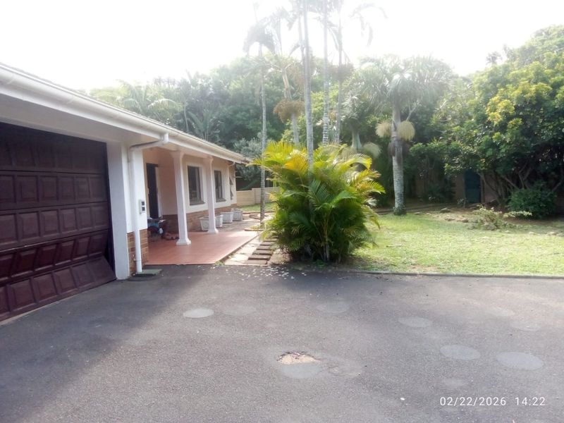 Front exterior view of the house featuring a garage, covered patio area, and a paved driveway with some surface wear.