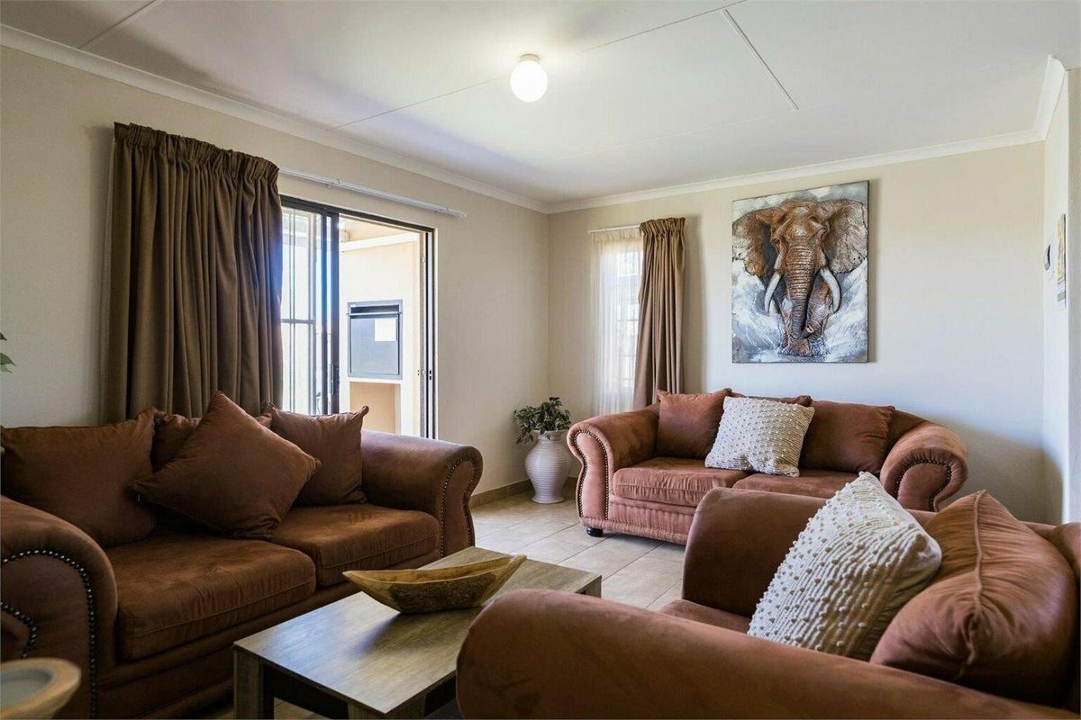A comfortable living room featuring tiled flooring and a sliding glass door providing access to an outdoor area.