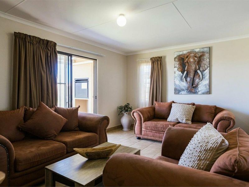 A comfortable living room featuring tiled flooring and a sliding glass door providing access to an outdoor area.