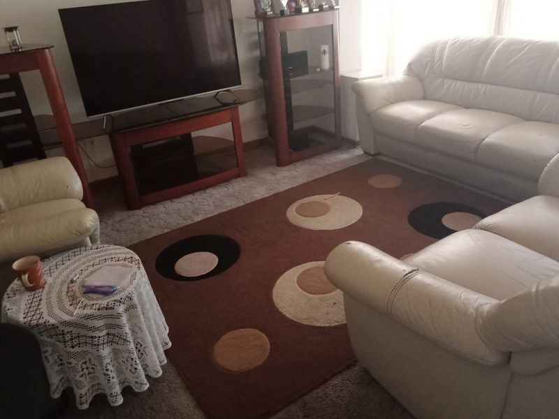 A comfortable living room area featuring carpeted flooring and neutral wall finishes, providing a functional space for relaxation and entertainment.