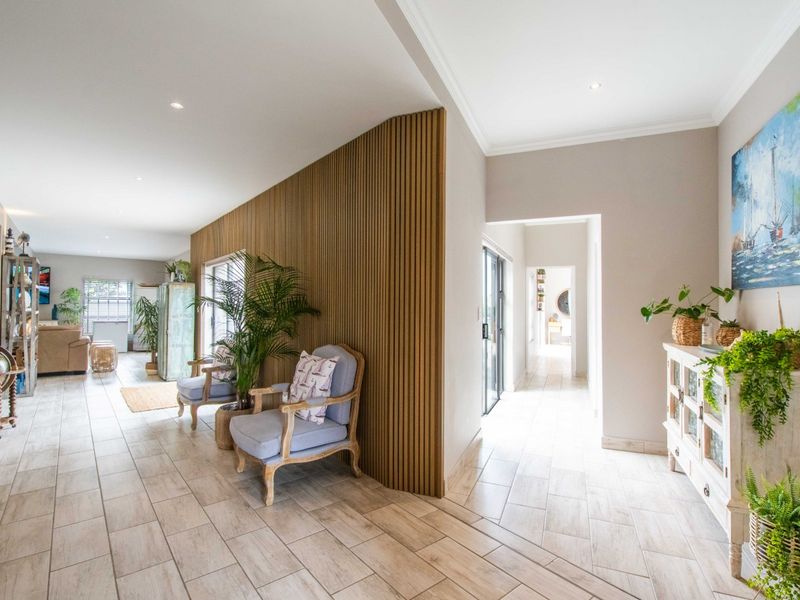 Spacious open-plan living area featuring modern timber slat wall cladding, neutral tiled flooring, and recessed downlighting, creating a bright and inviting atmosphere.