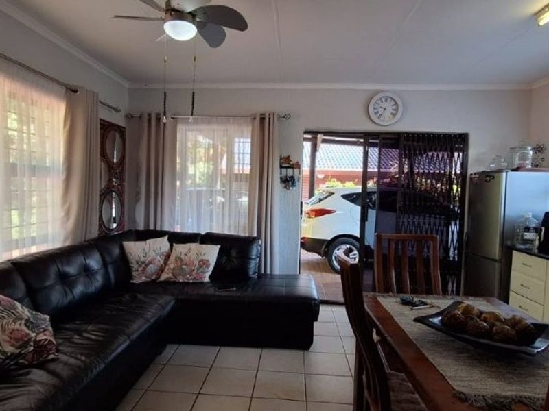 Open-plan living and dining area featuring tiled floors, a ceiling fan, and a split-system air conditioner, with direct access to the exterior.