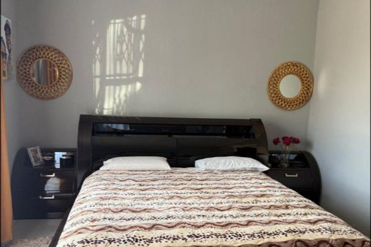 A well-maintained bedroom featuring neutral wall paint and decorative crown molding.