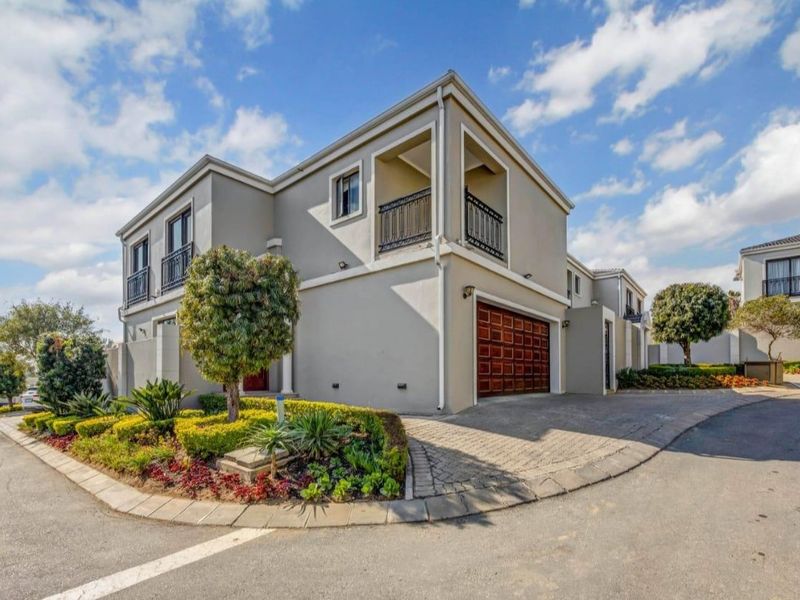A well-maintained double-story residential property featuring a paved driveway, integrated double garage, and a private balcony with wrought iron railings.