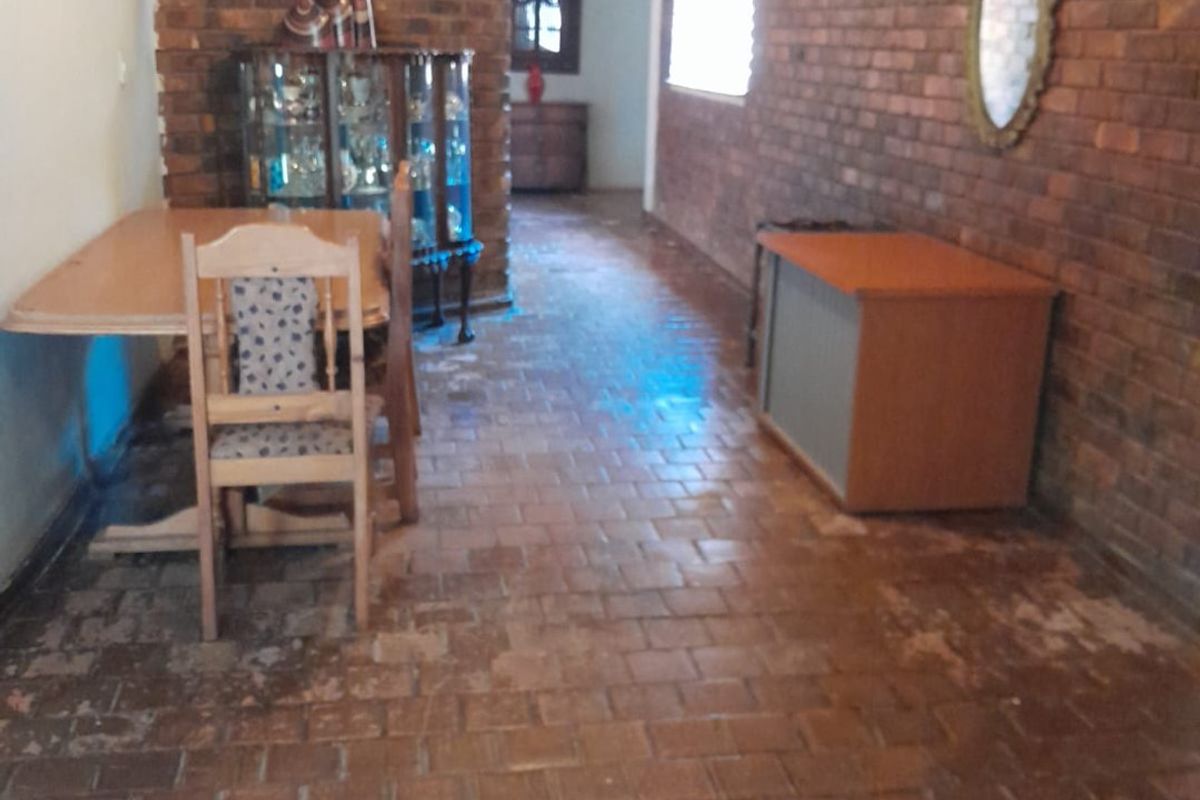 Living area featuring rustic exposed brick walls and traditional terracotta tile flooring, offering a character-filled space with potential for modernization.