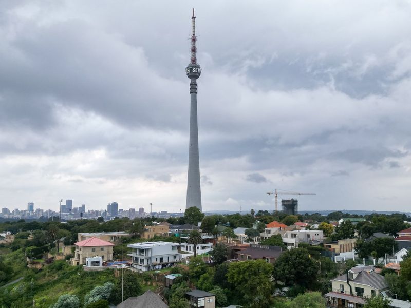 An aerial view of the surrounding neighbourhood featuring the prominent telecommunications tower and distant city skyline.