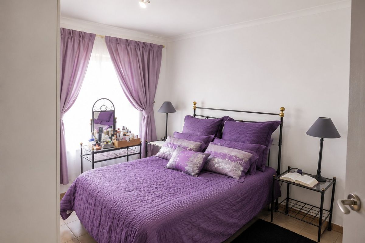 A well-maintained bedroom featuring tiled flooring, neutral walls, and a ceiling-mounted light fixture, offering a clean and functional living space.