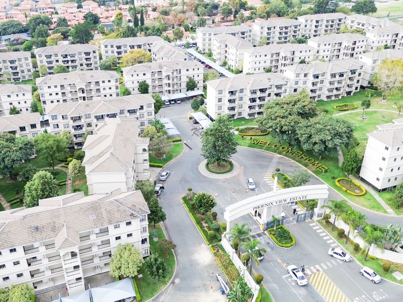 Aerial view of Phoenix View Estate, showcasing the gated entrance, landscaped grounds, and multiple residential apartment blocks within the complex.