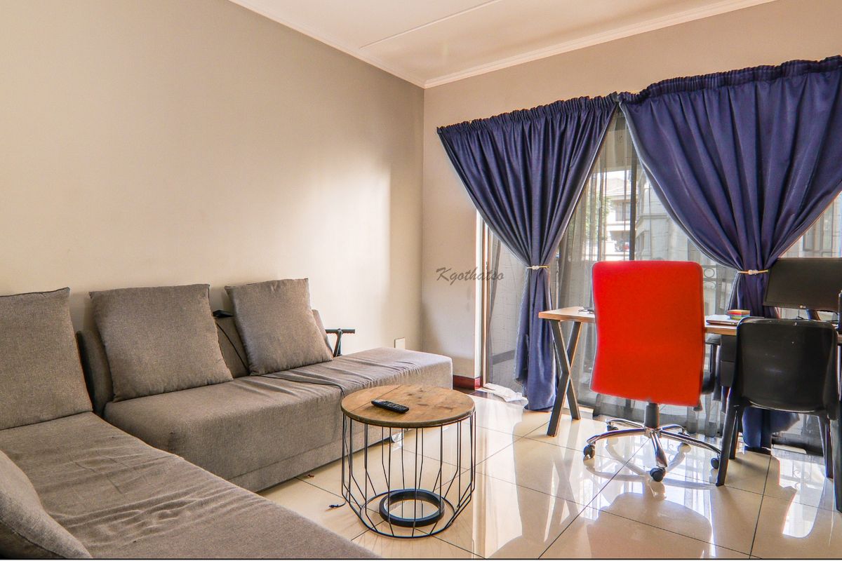 A living room area featuring tiled flooring and a sliding glass door providing access to the exterior.