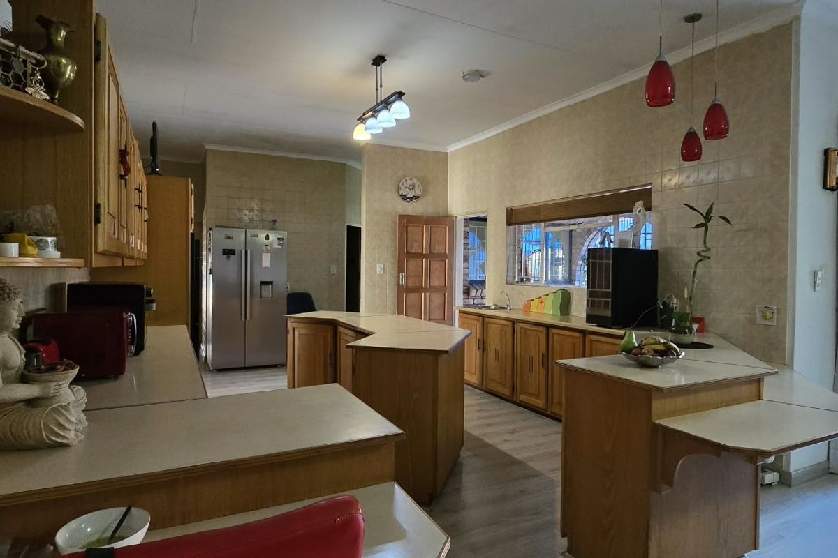 Spacious kitchen featuring wooden cabinetry, laminate countertops, tiled backsplash, and direct access to the outdoor patio area.
