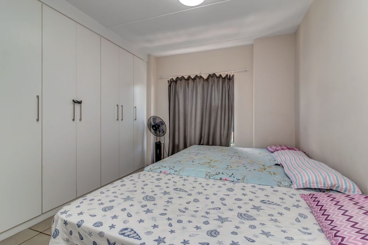 A functional bedroom featuring extensive floor-to-ceiling built-in cupboards providing ample storage space.
